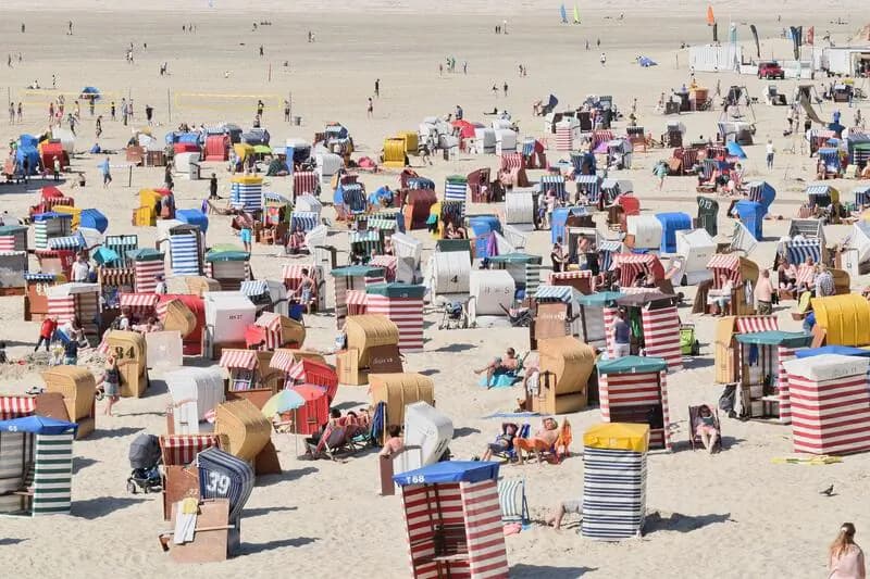 Borkum Strand mit vielen bunten Strandkörben und Menschen.